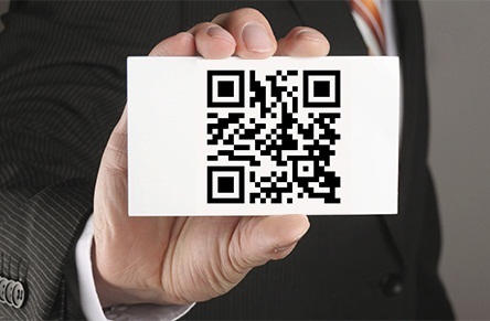 businessman holding a card with qr code which means contact us