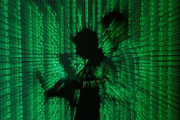 An illustration picture shows a projection of binary code on a man holding a laptop computer, in an office in Warsaw June 24, 2013. REUTERS/Kacper Pempel/Illustration/File Photo